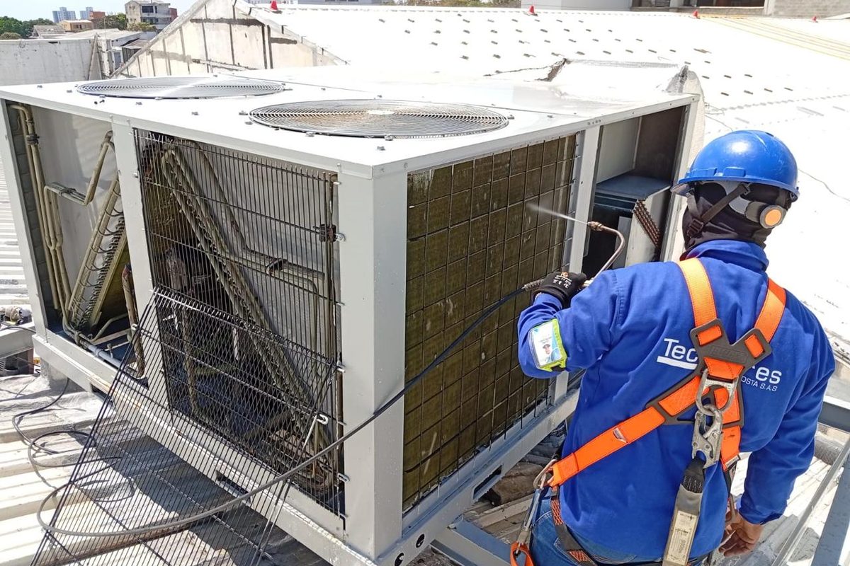Técnico TecniAires con arnés realizando mantenimiento industrial en altura